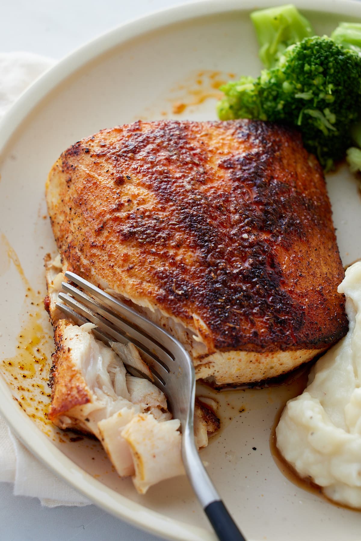 mahi mahi being cut with a fork