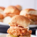 fried chicken slider on plate with other sandwiches in background