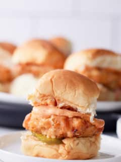 fried chicken slider on plate with other sandwiches in background