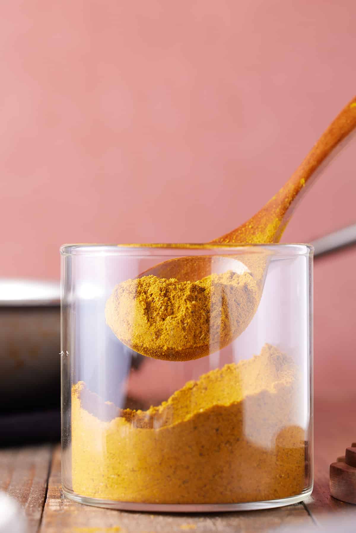spoon taking out jamaican curry powder out of glass