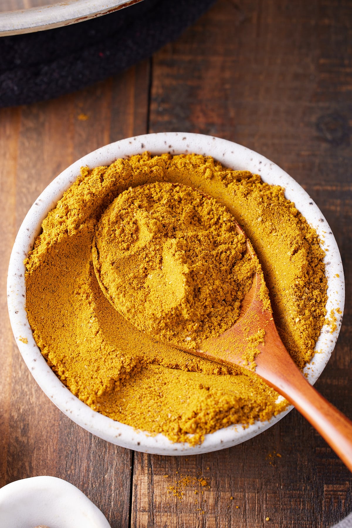 jamaican curry powder in bowl with spoon sticking out