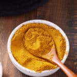 jamaican curry powder in bowl with spoon sticking out