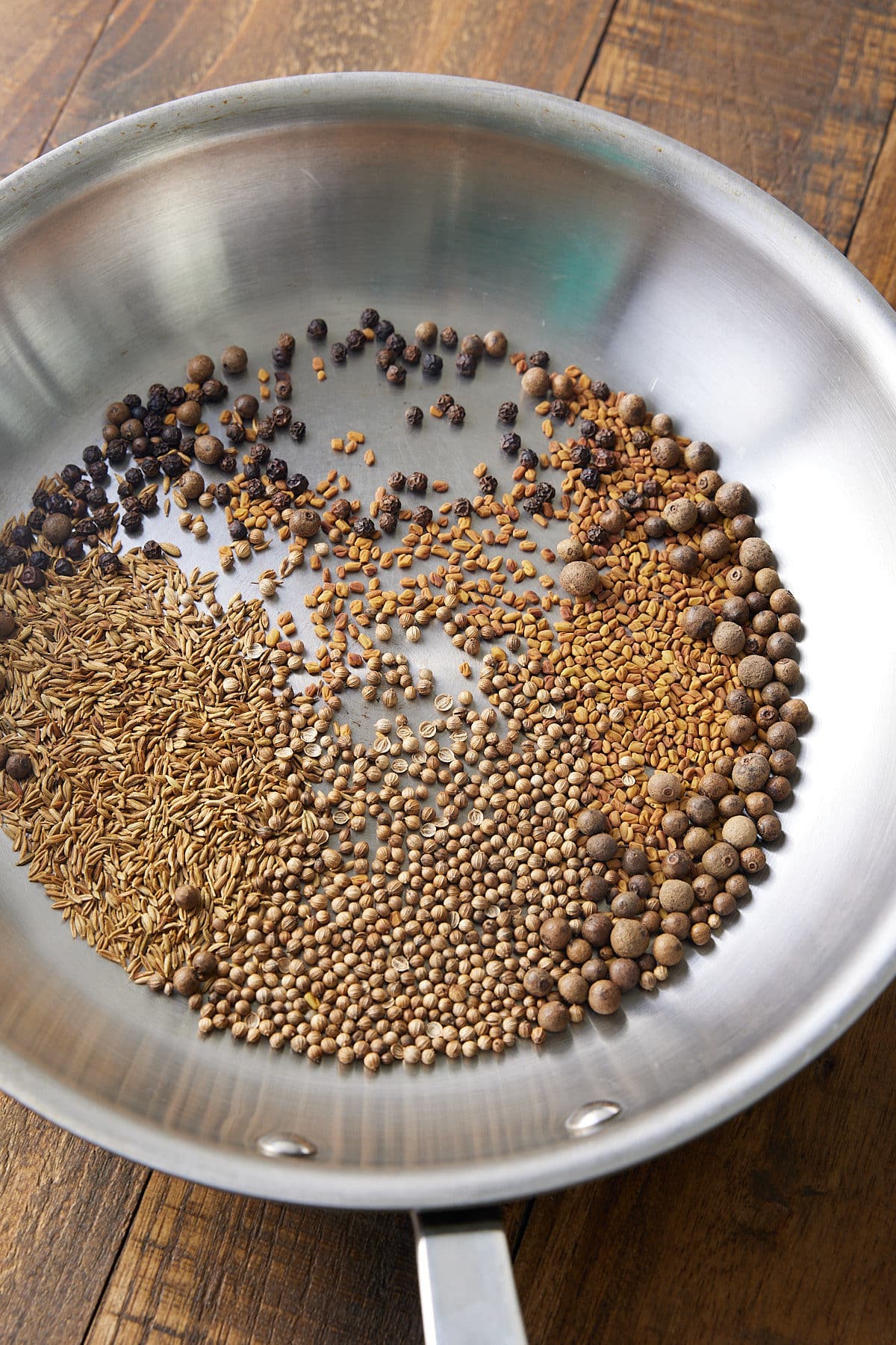 whole spices in a skillet toasting