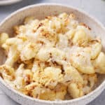 bowl filled with roasted air fryer cauliflower garnished with shredded Parmesan cheese