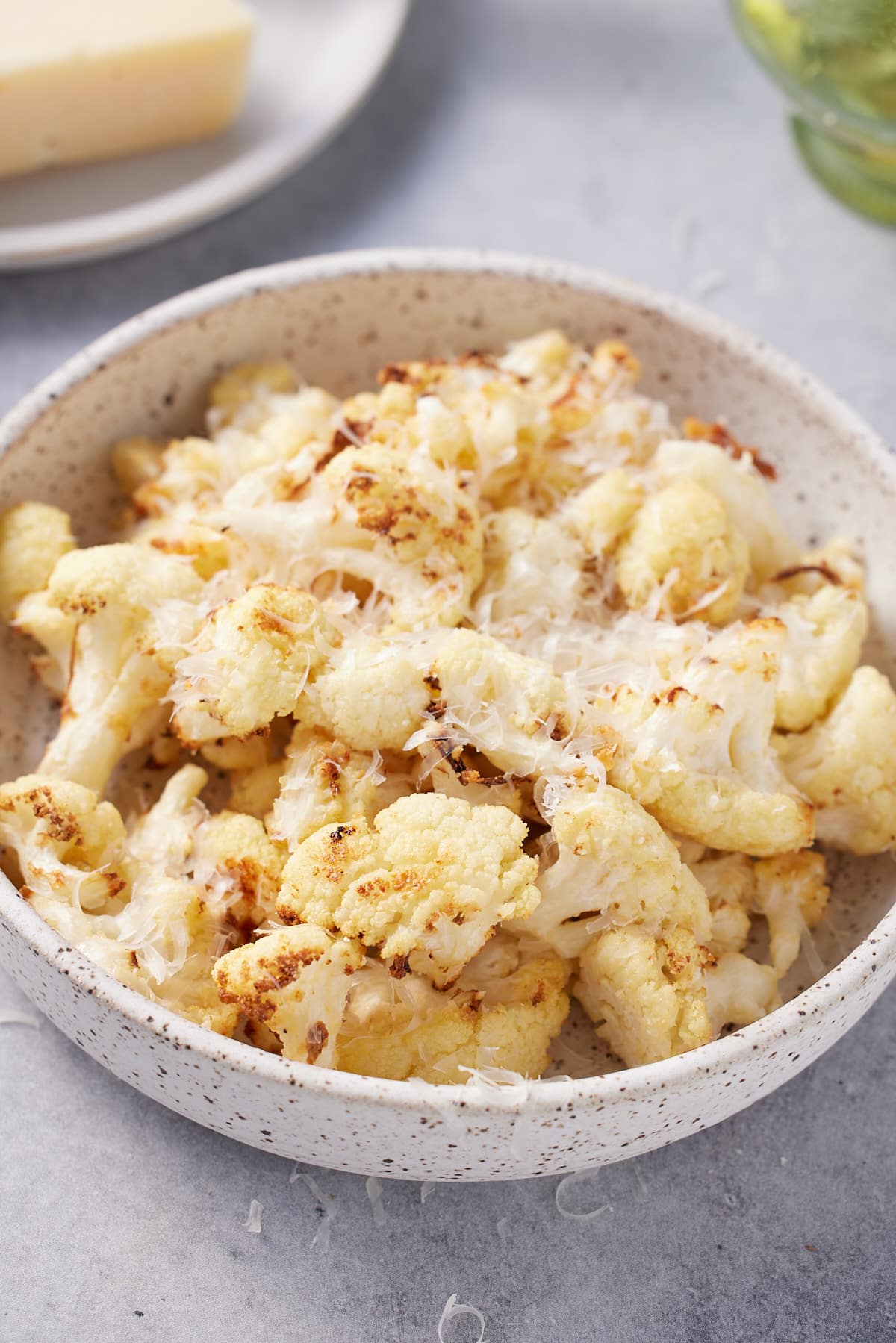 bowl filled with roasted air fryer cauliflower garnished with shredded Parmesan cheese