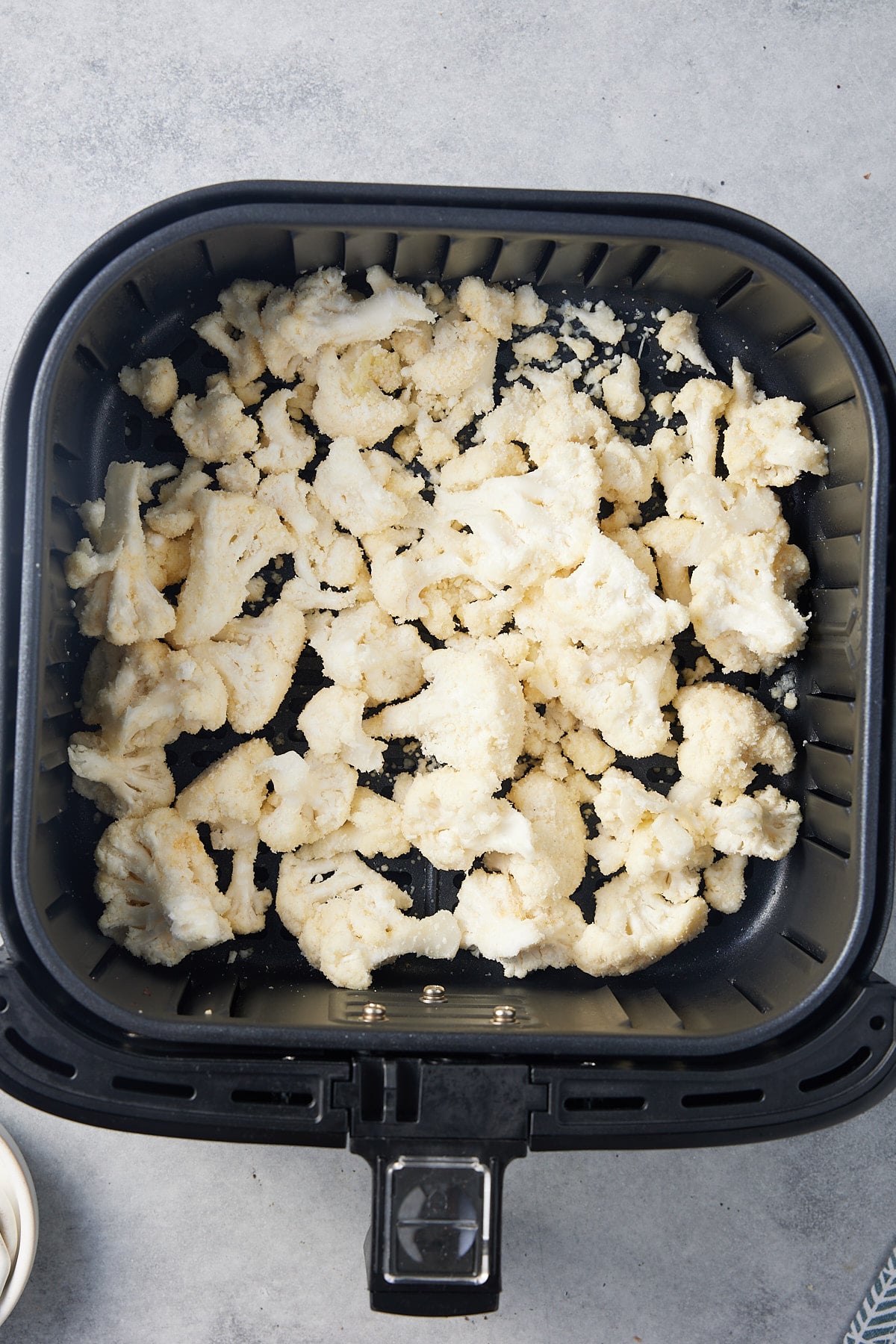 raw cauliflower in air fryer basket