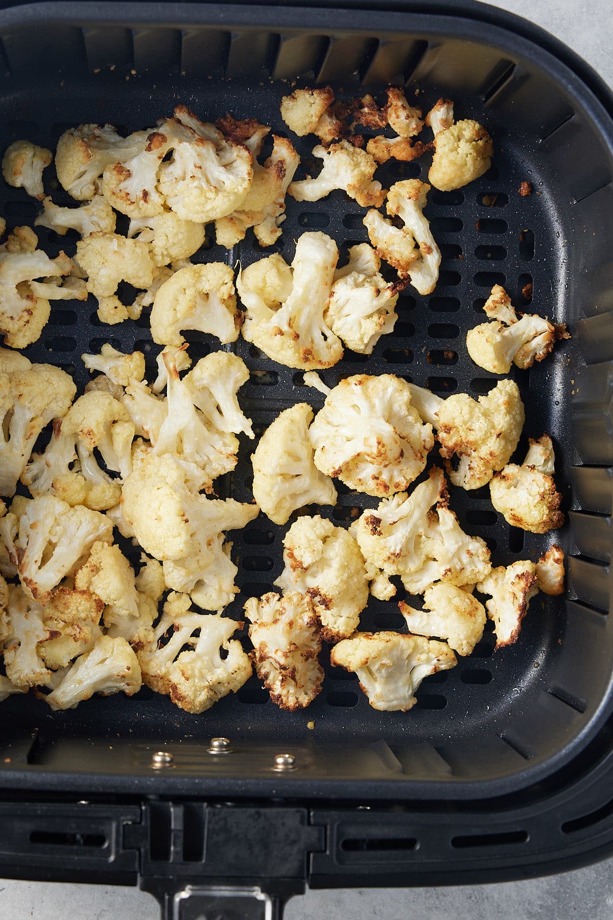 roasted cauliflower florets in air fryer basket