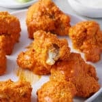 crispy breaded air fryer cauliflower wings coated in wing sauce