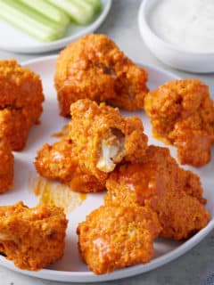 crispy breaded air fryer cauliflower wings coated in wing sauce