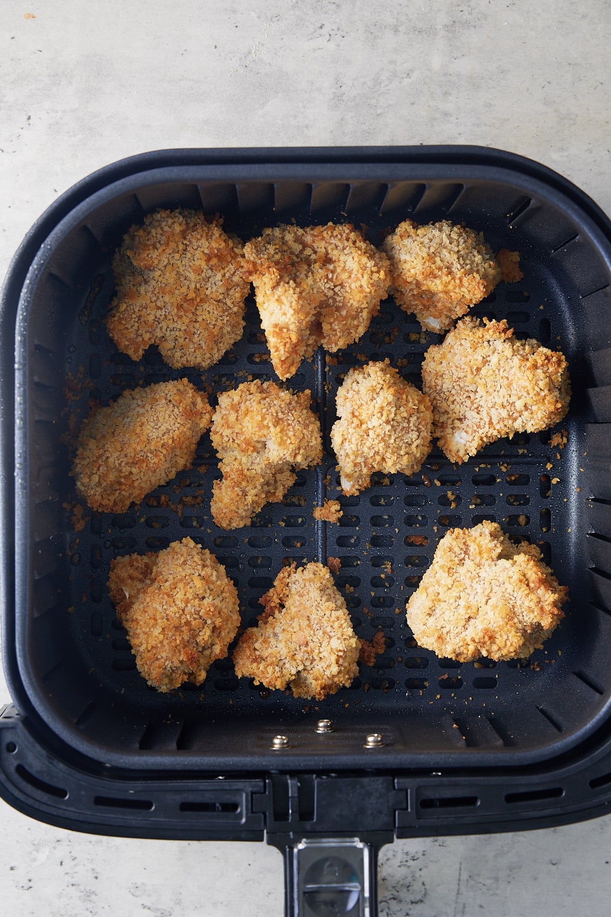 air fryer basket filled with cooked cauliflower wings