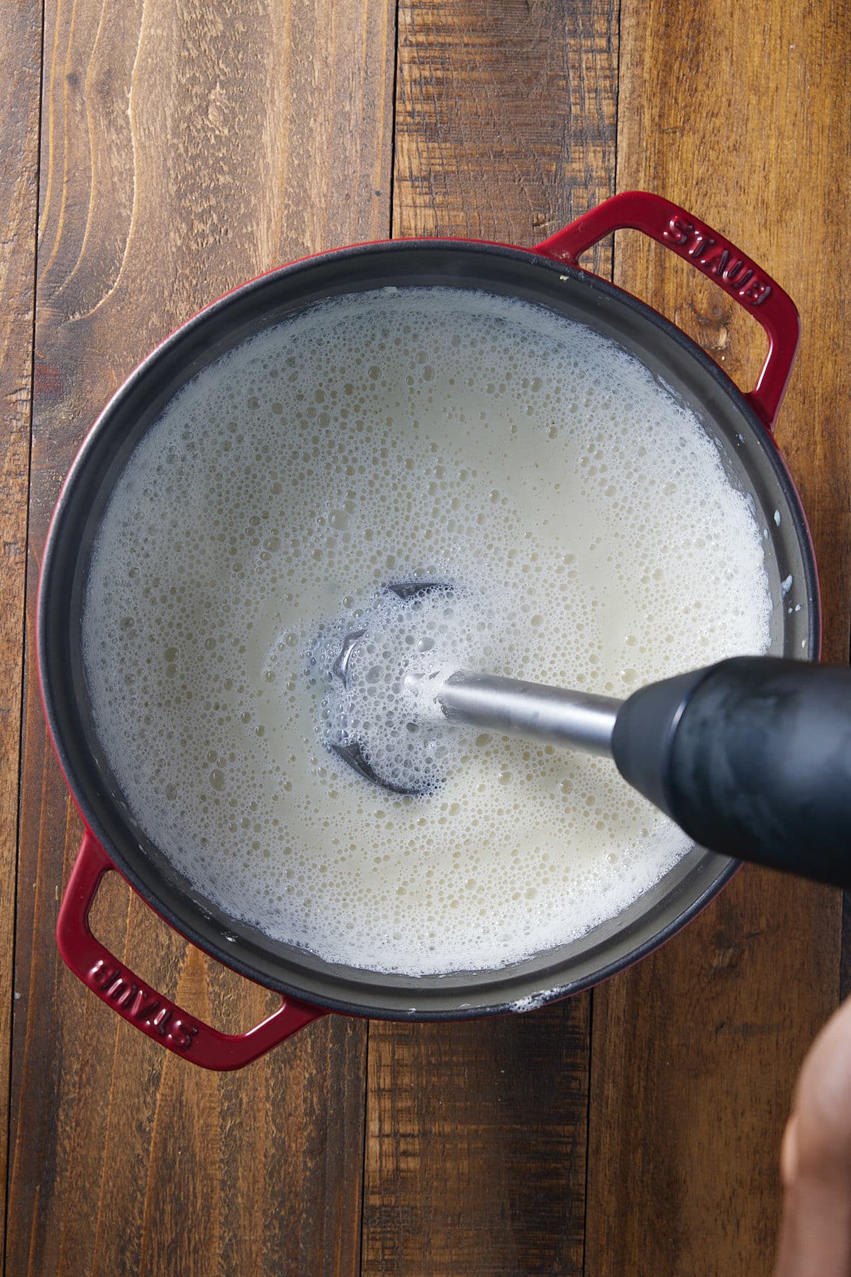 Cauliflower soup being blended in the pot with an immersion blender