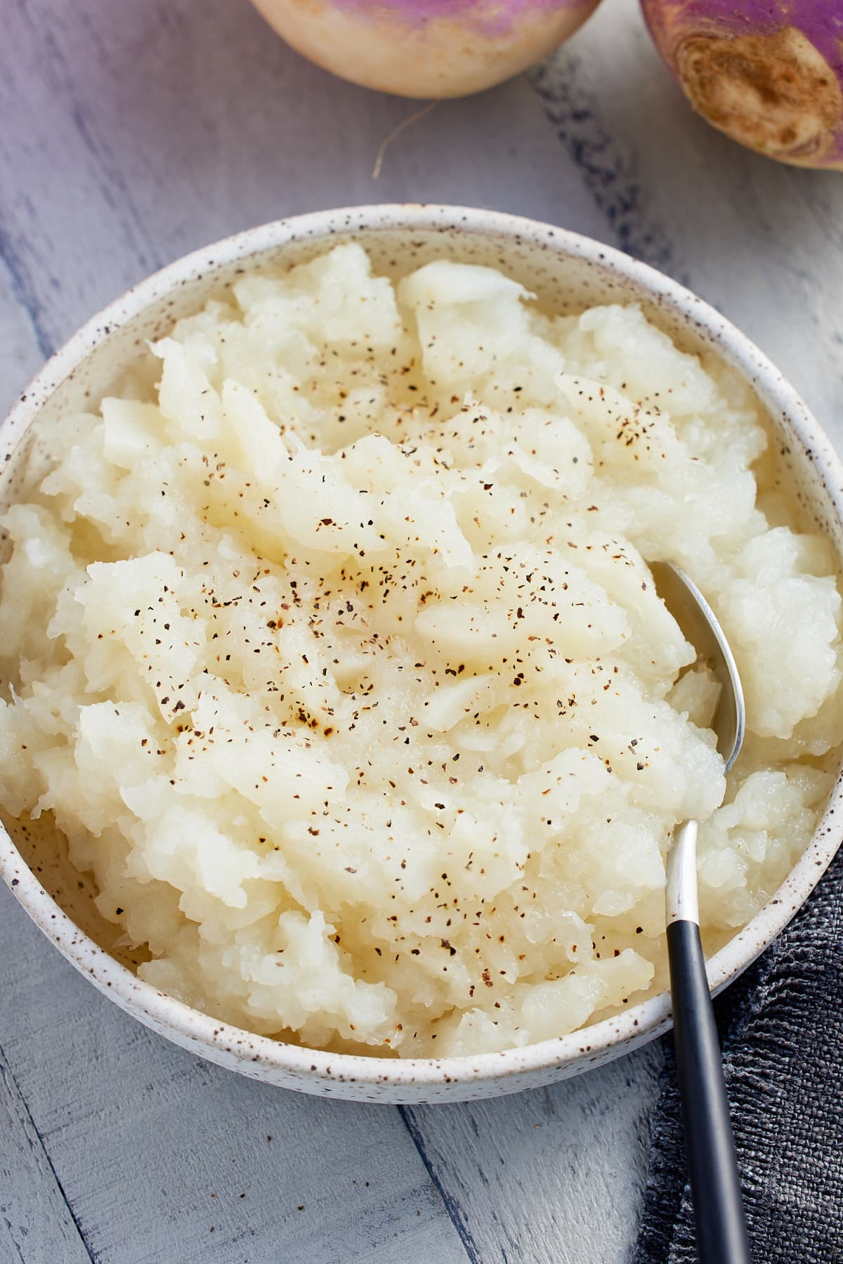 Bowl of mashed turnips with a spoon