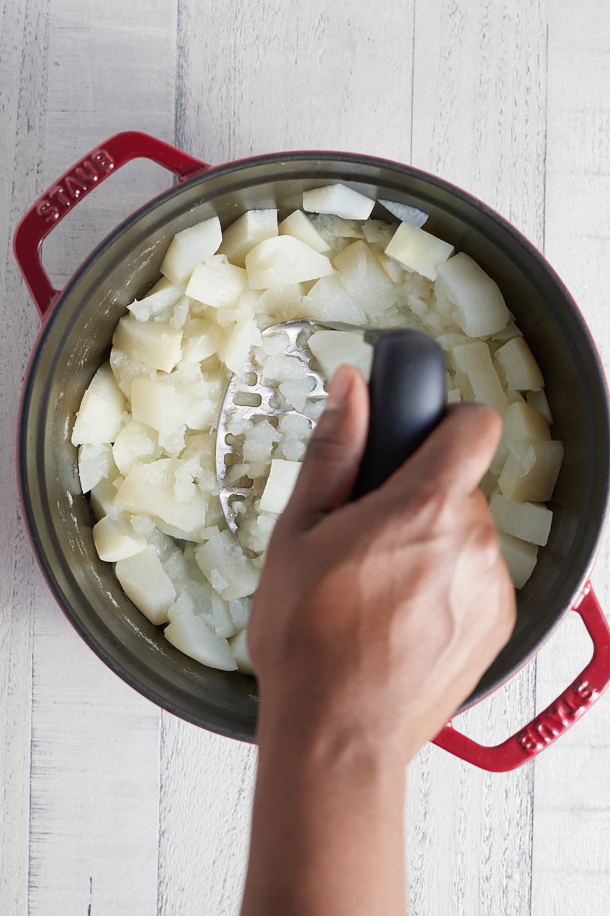mashing cooked turnips