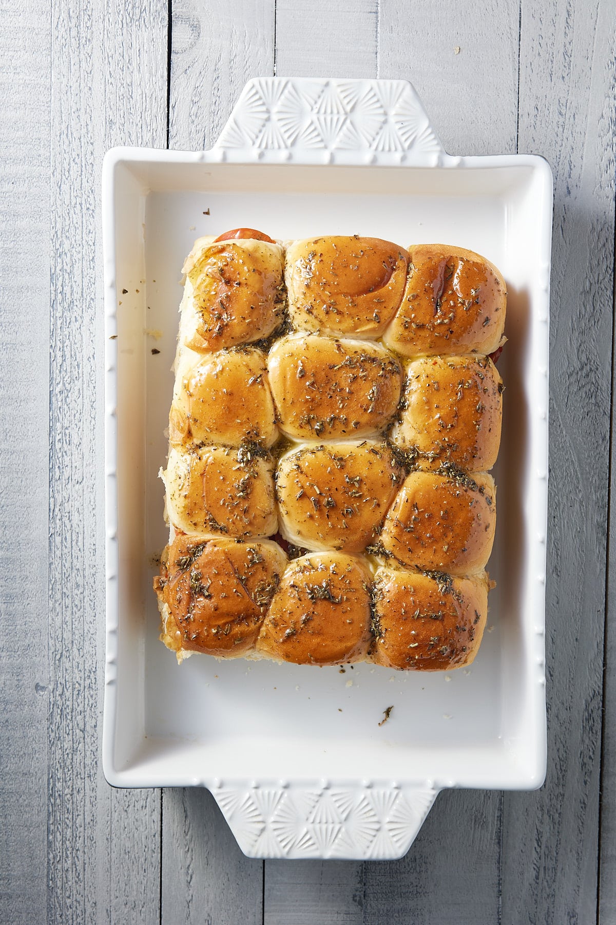 white oven proof dish filled with baked pizza sliders