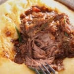 braised beef short rib served on top of a bowl of creamy polenta