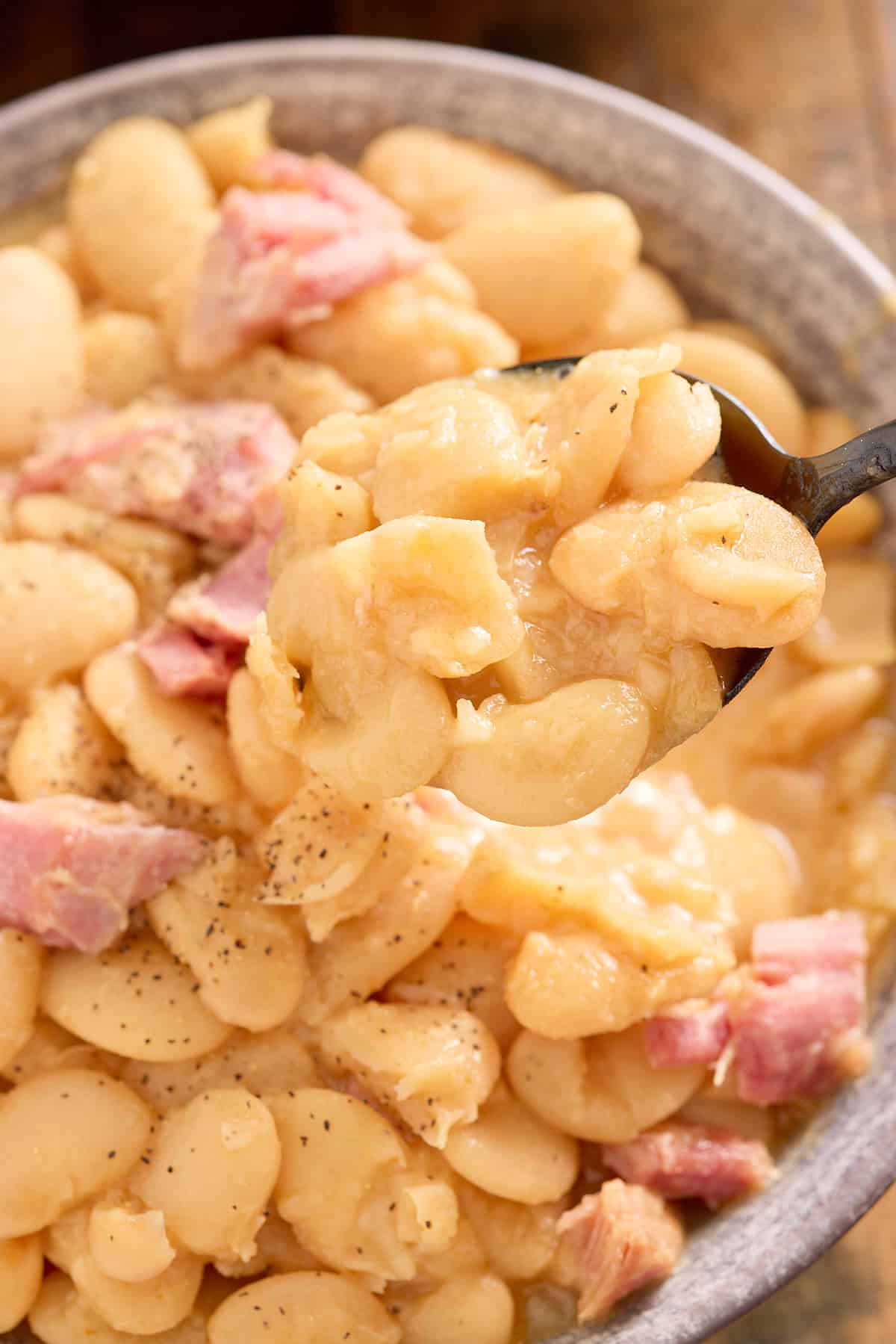 close up image of bowl of butter beans topped with shredded smoked turkey