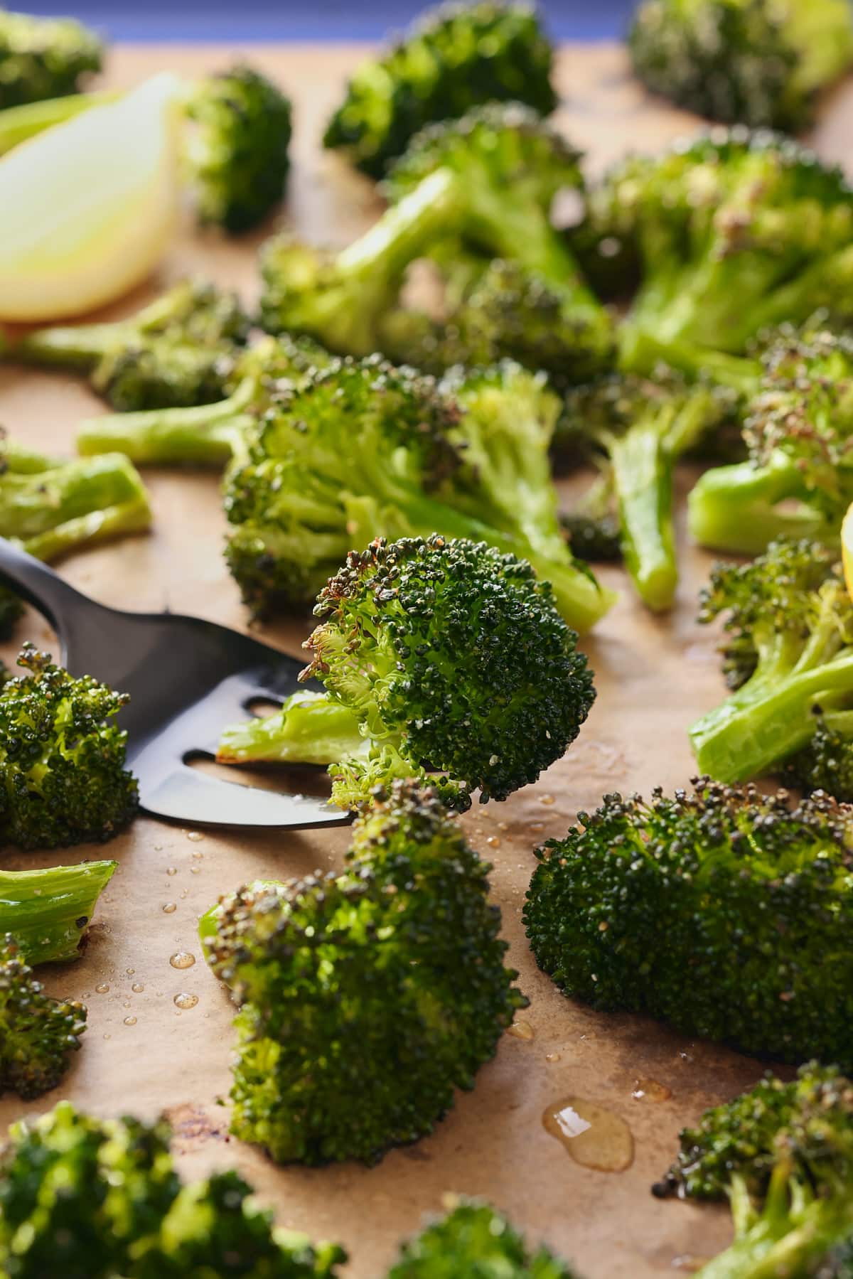 oven roasted broccoli on a baking sheet with a fork