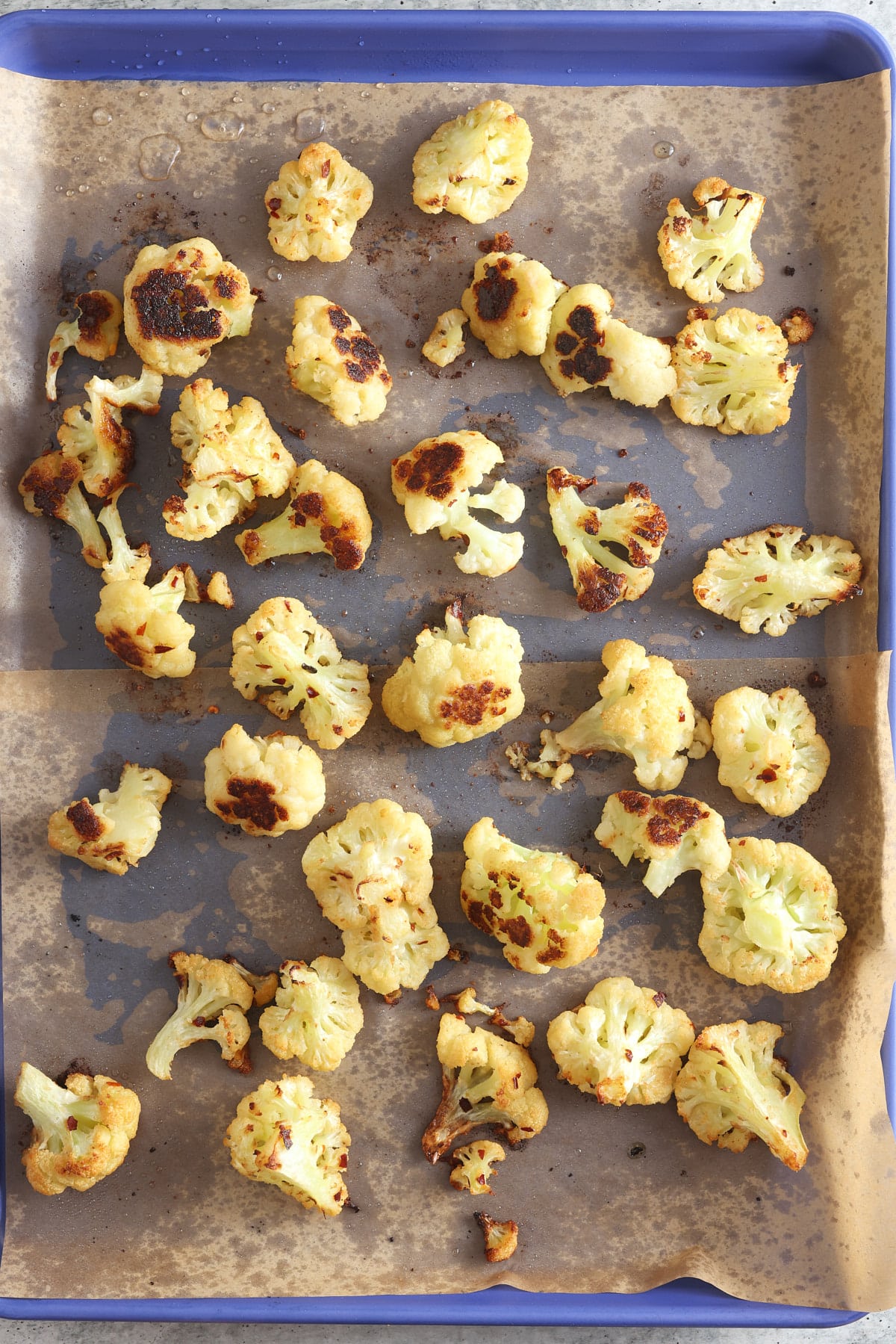 Cooked oven roasted cauliflower still on the baking sheet.