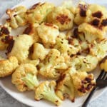 oven roasted cauliflower on a plate with a fork.