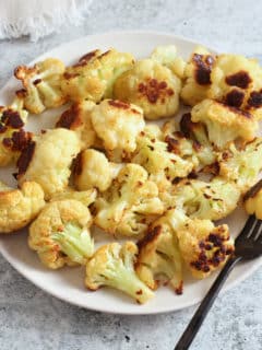 oven roasted cauliflower on a plate with a fork.