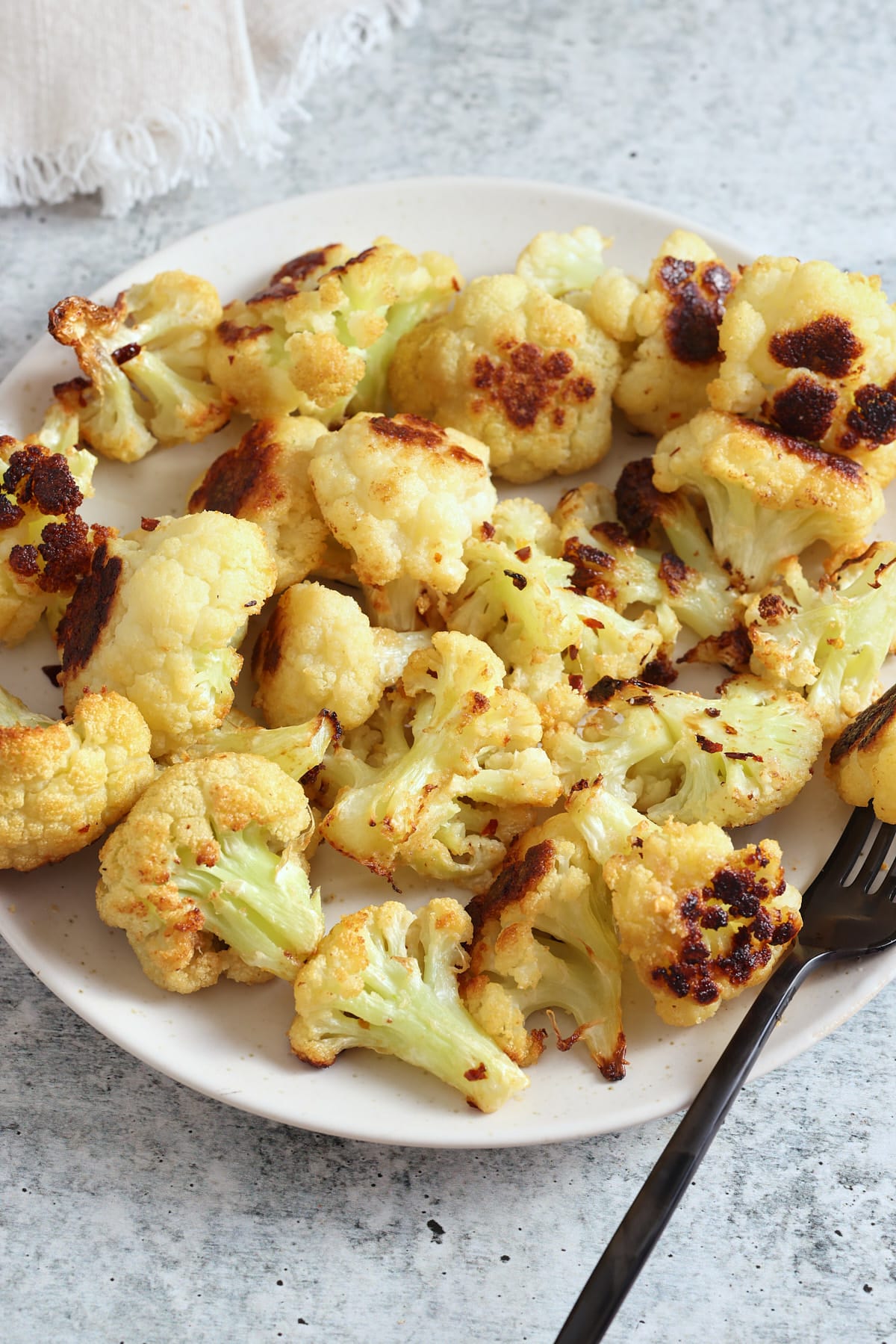 oven roasted cauliflower on a plate with a fork.