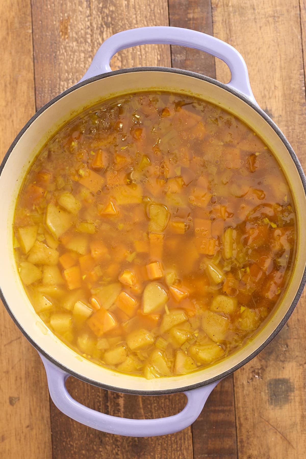 Dutch oven filled with cooked sweet potato soup prior to being blended