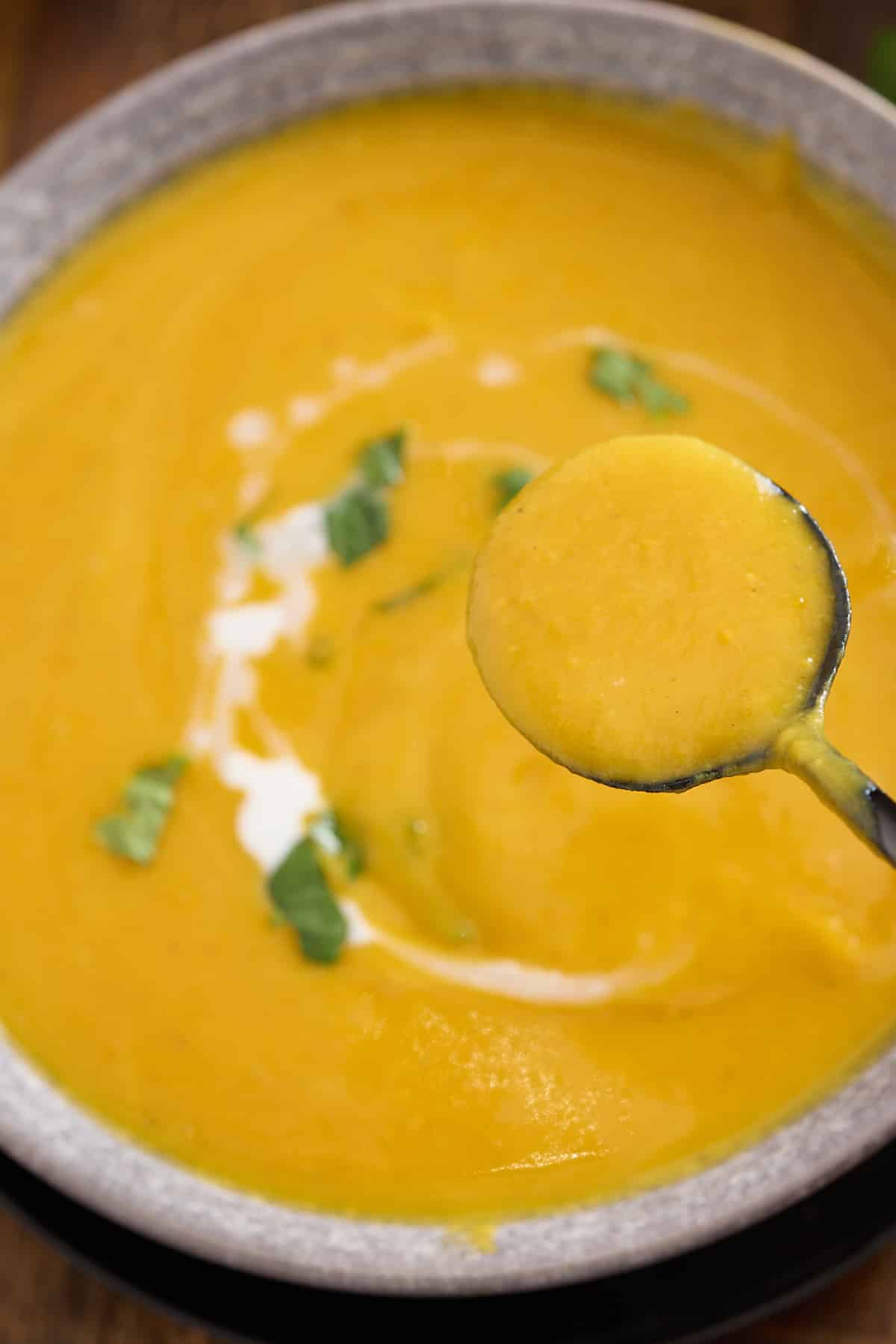 bowl of sweet potato soup with a soup spoon