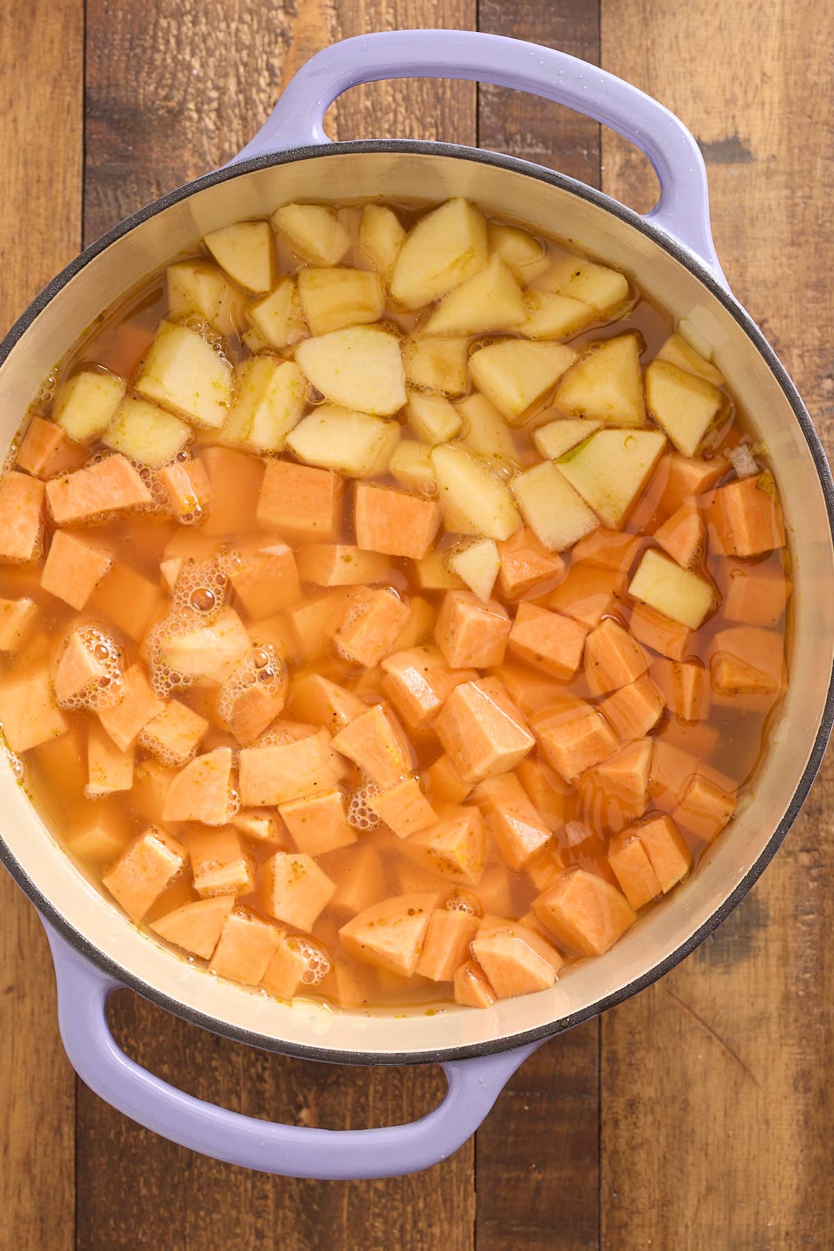 Dutch oven filled with chopped sweet potato, apple and vegetable broth