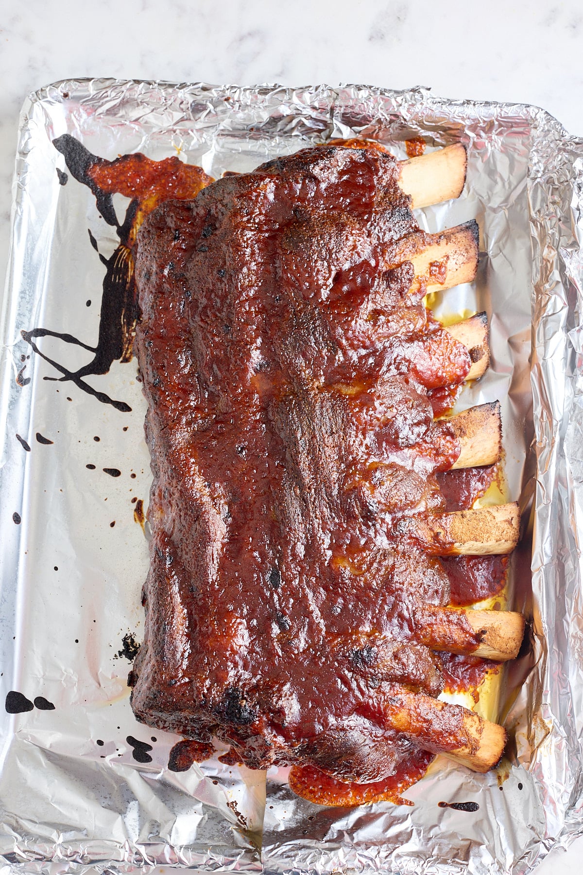 foil line roasting pan filled with oven baked beef ribs
