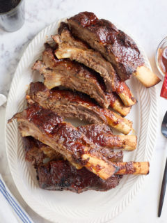 white serving platter filled with oven baked beef ribs