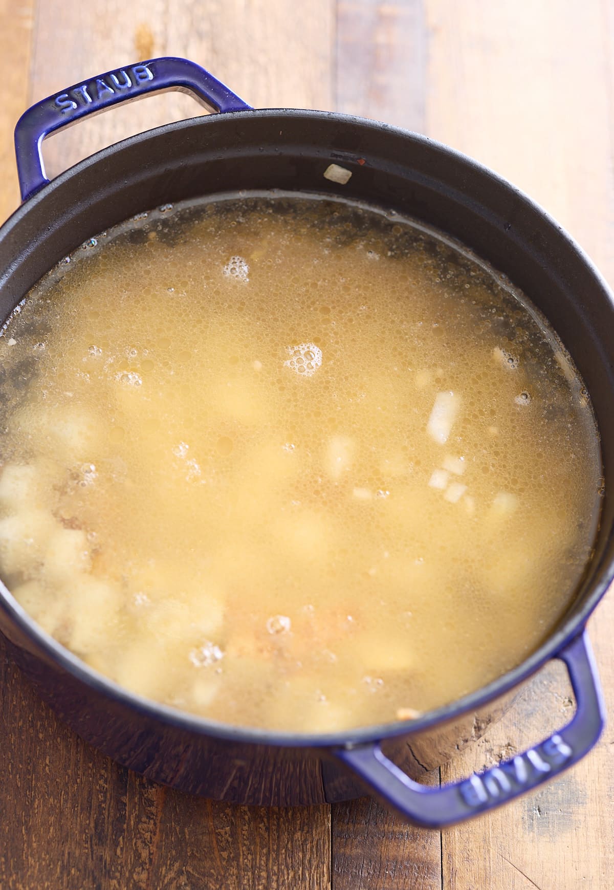 Broth and potatoes added to the pot.