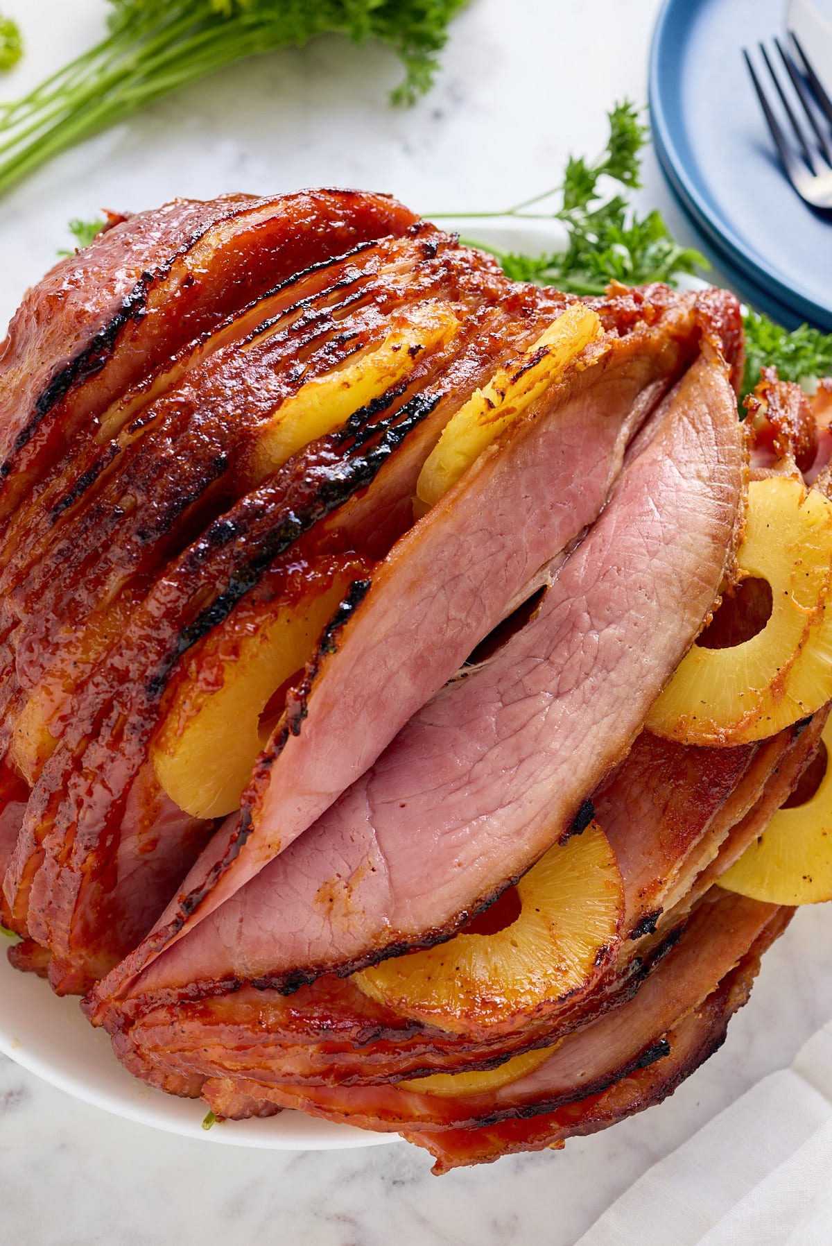 Fresh baked ham plated on a platter on the table.