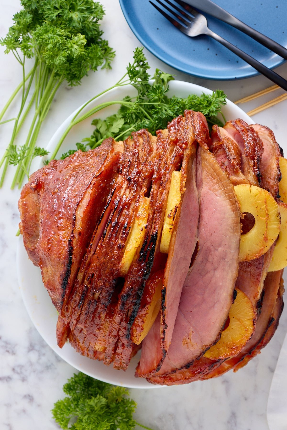 Fresh baked ham plated on a platter on the table.