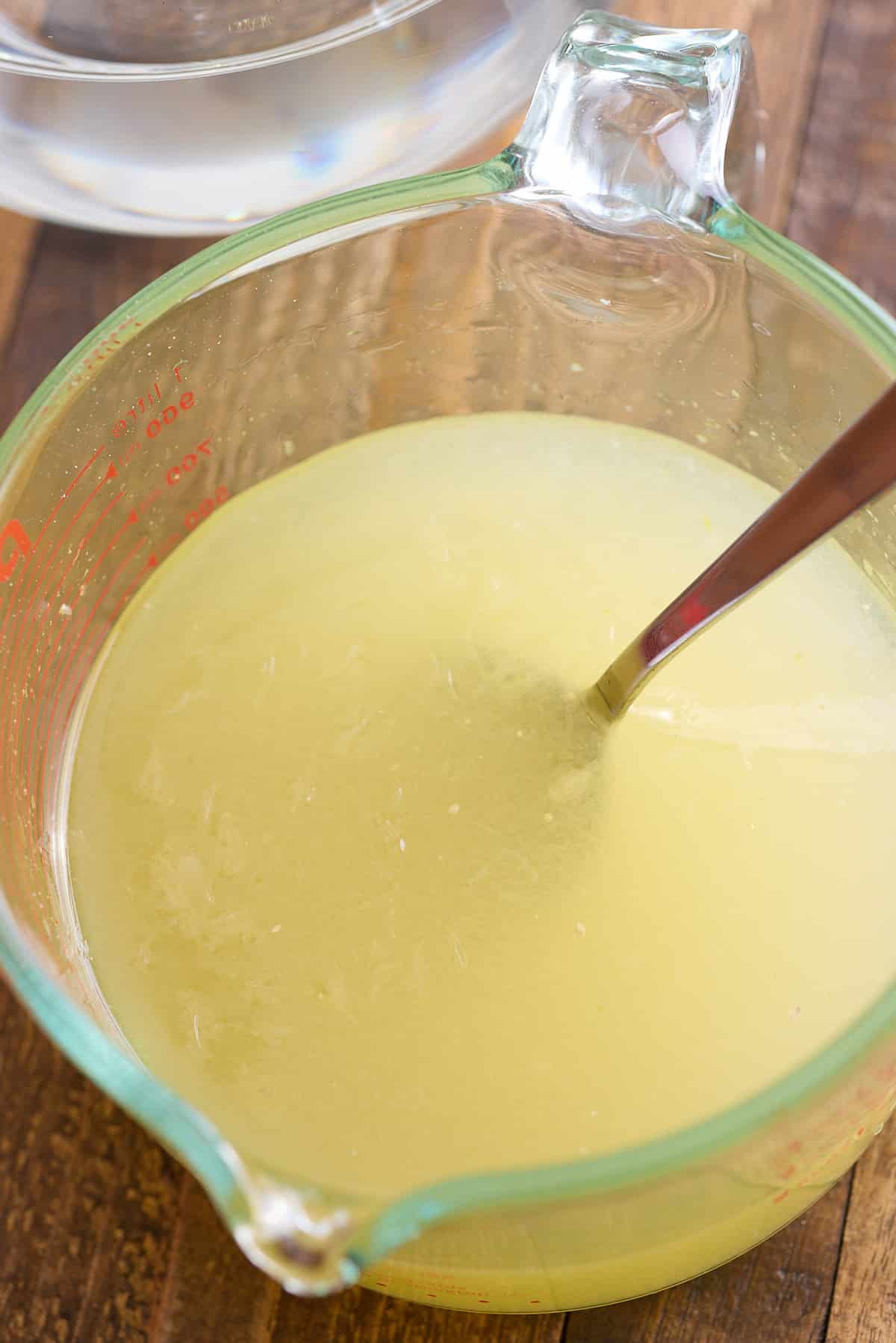 a measuring jug filled with lemon juice and sugar