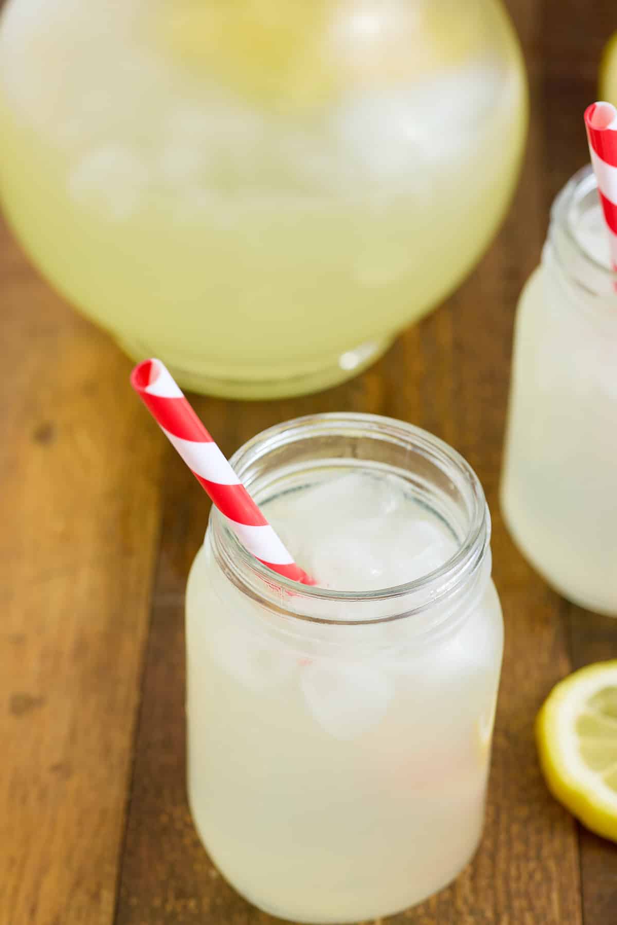 glass filled with classic lemonade with a red and white drinking straw