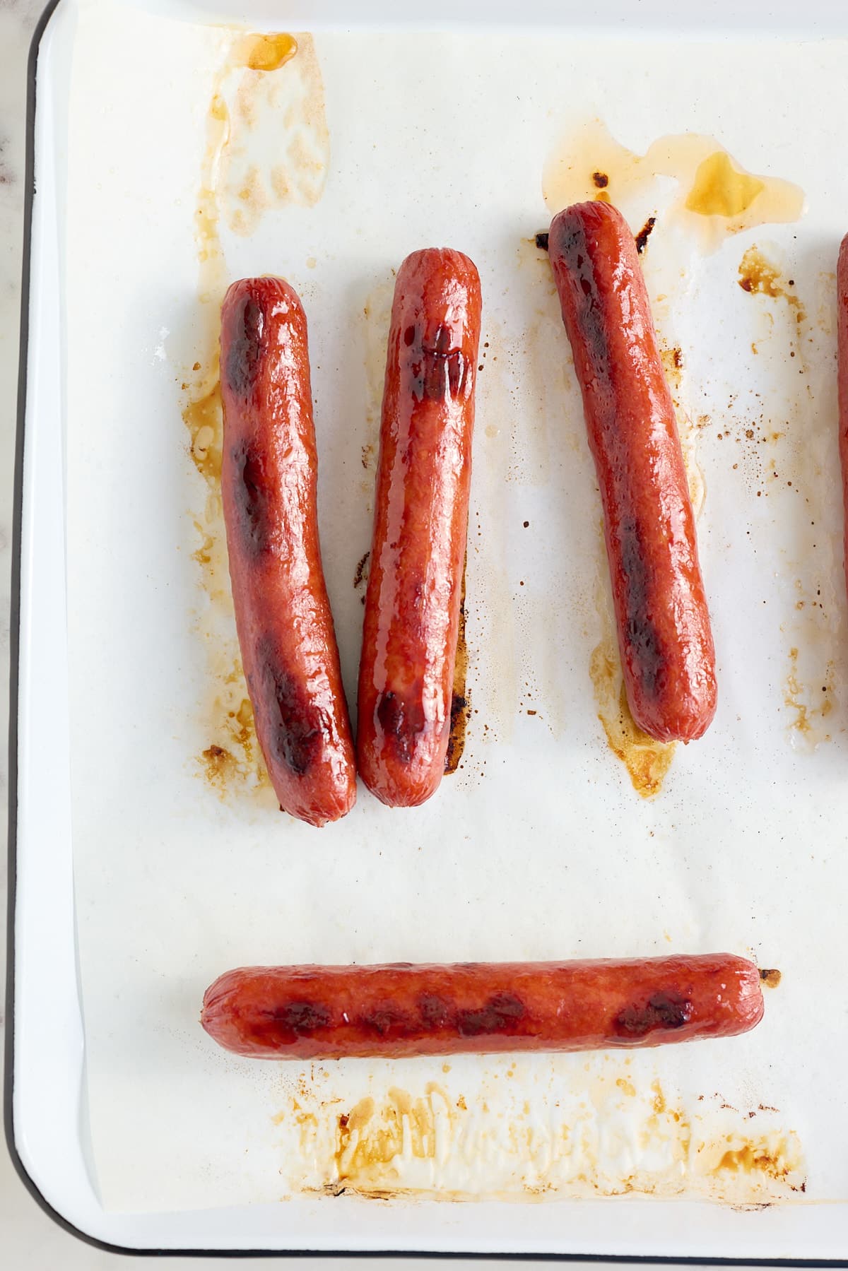 white baking sheet with cooked hot dogs