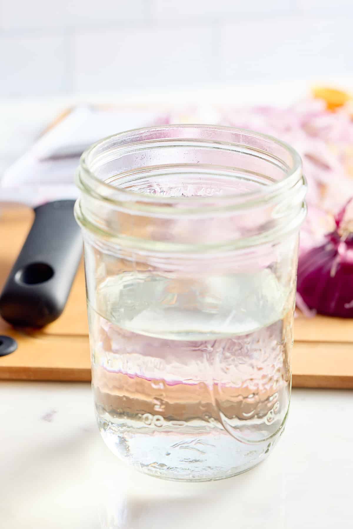 a jar filled with water, white vinegar, sugar and salt