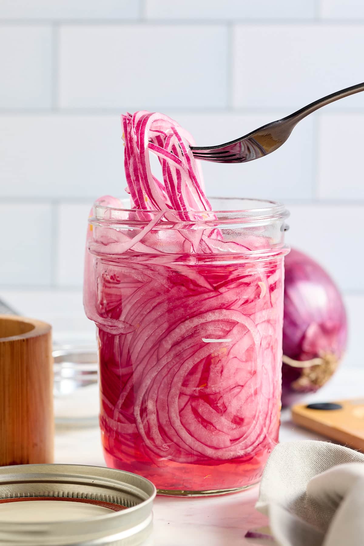 a jar of quick pickled red onions and a fork full of onions