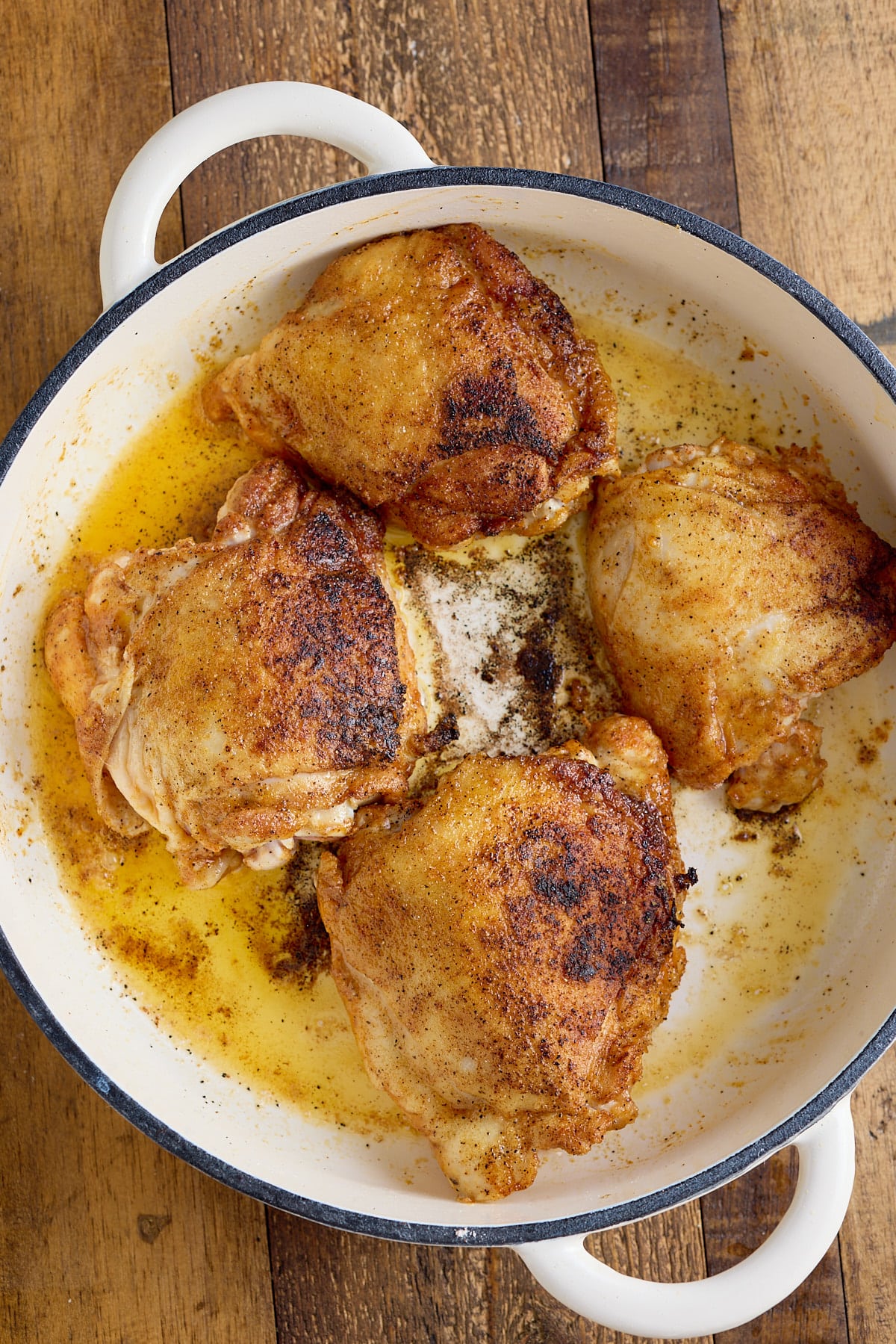 Dutch oven with cooked bone-in skin-on chicken thighs