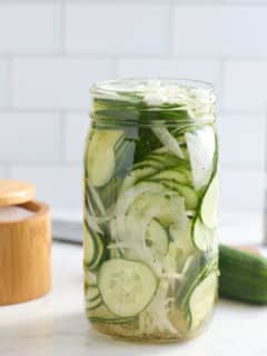 glass mason jar filled with cucumber and sweet onion refrigerator pickles