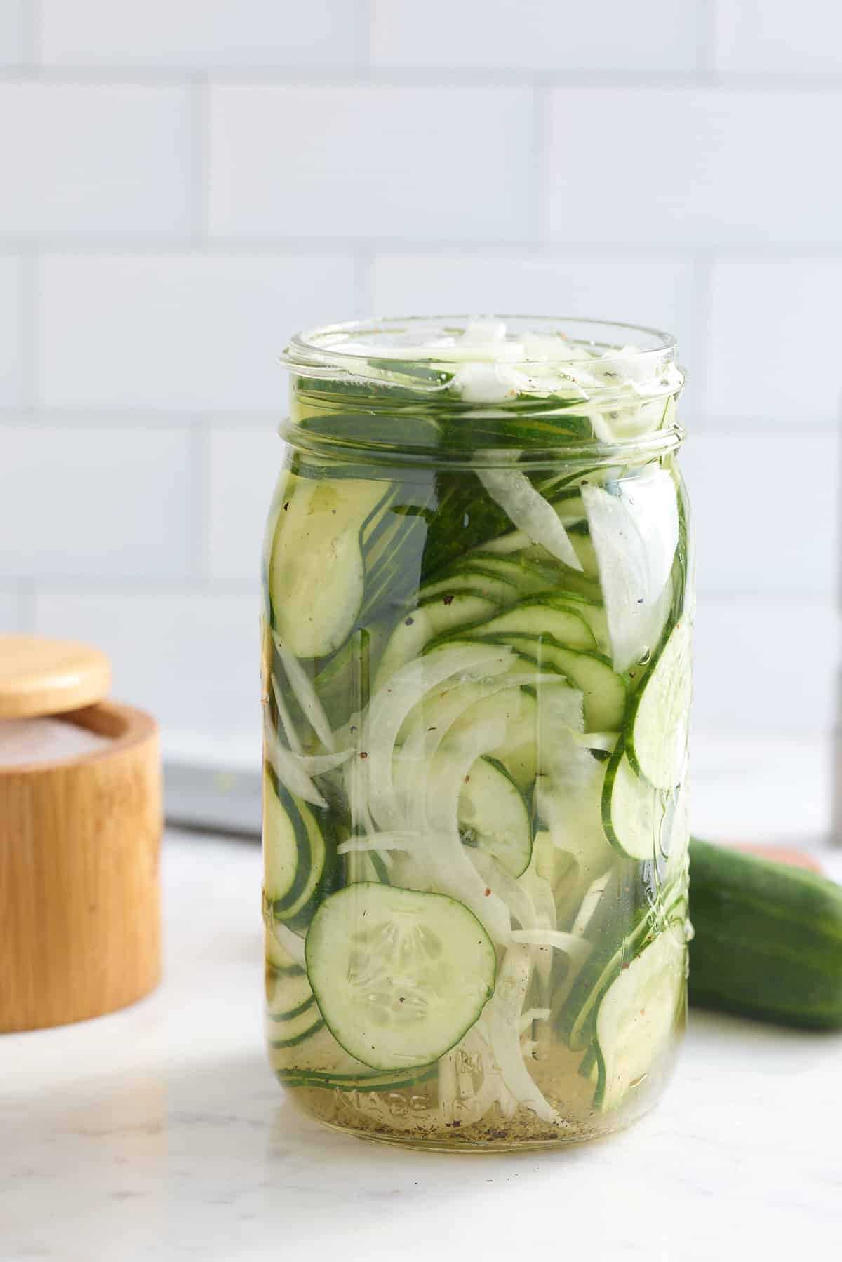 glass mason jar filled with cucumber and sweet onion refrigerator pickles