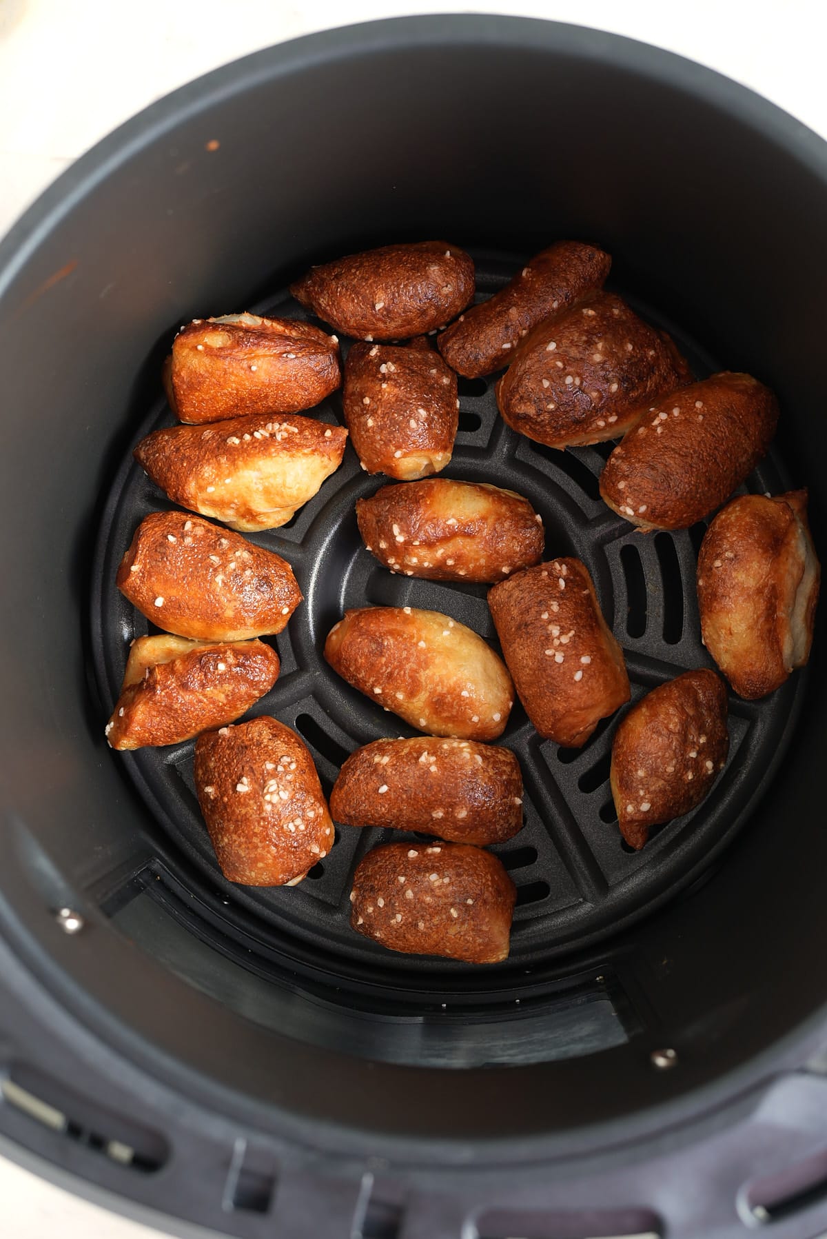 an air fryer basket filled with cooked pretzel bites