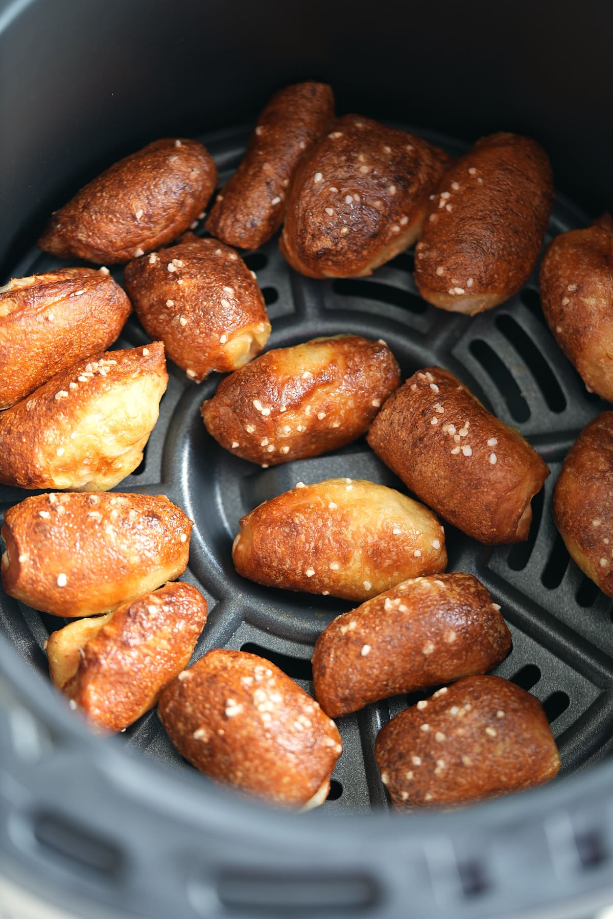 an air fryer basket filled with cooked pretzel bites