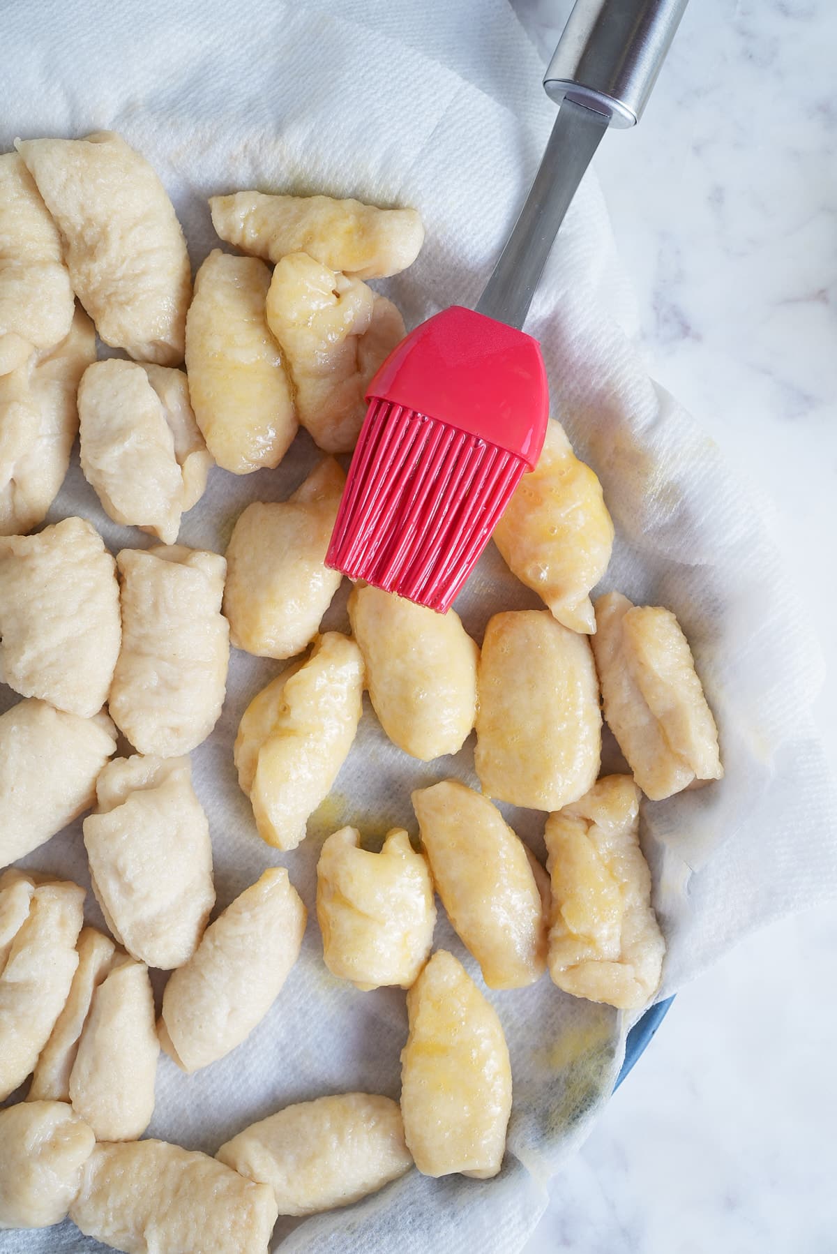 dough balls being brushed with beaten egg