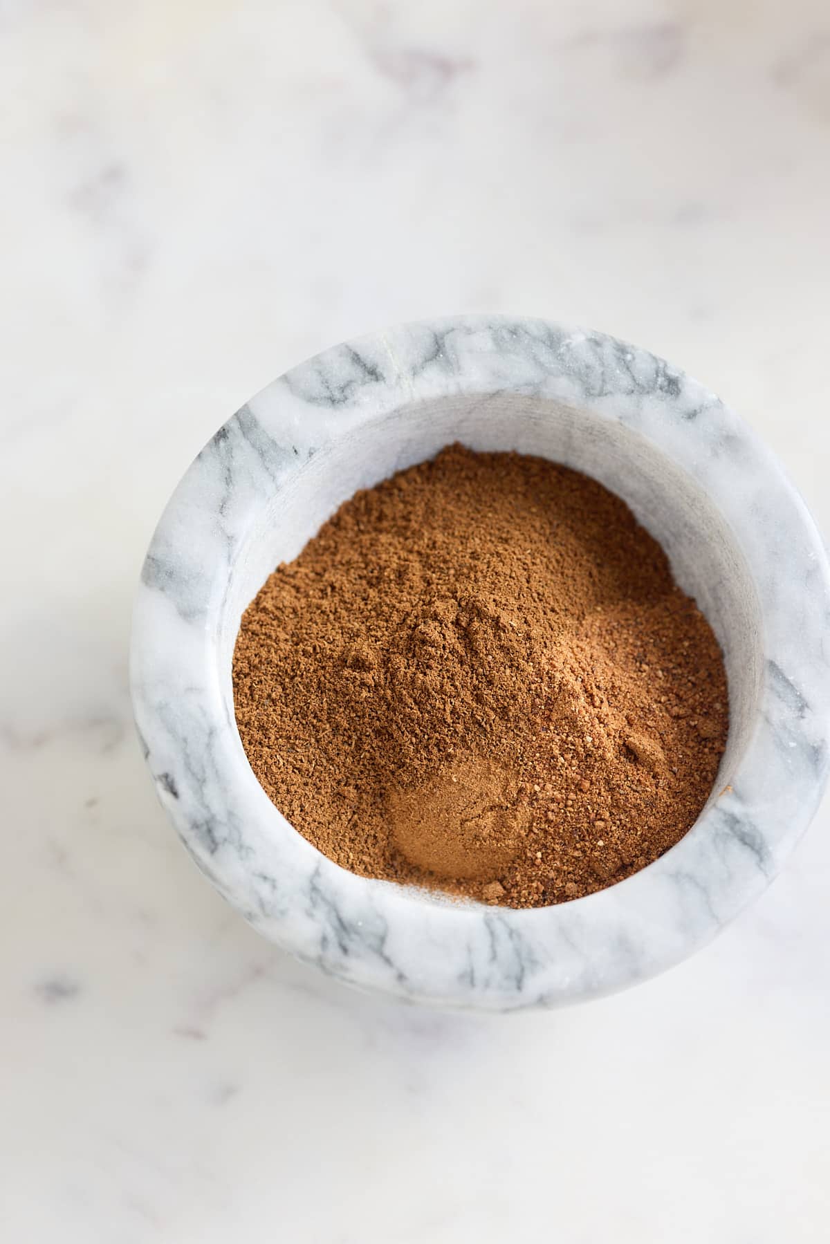 spice ingredients mixed together in a mortar bowl.