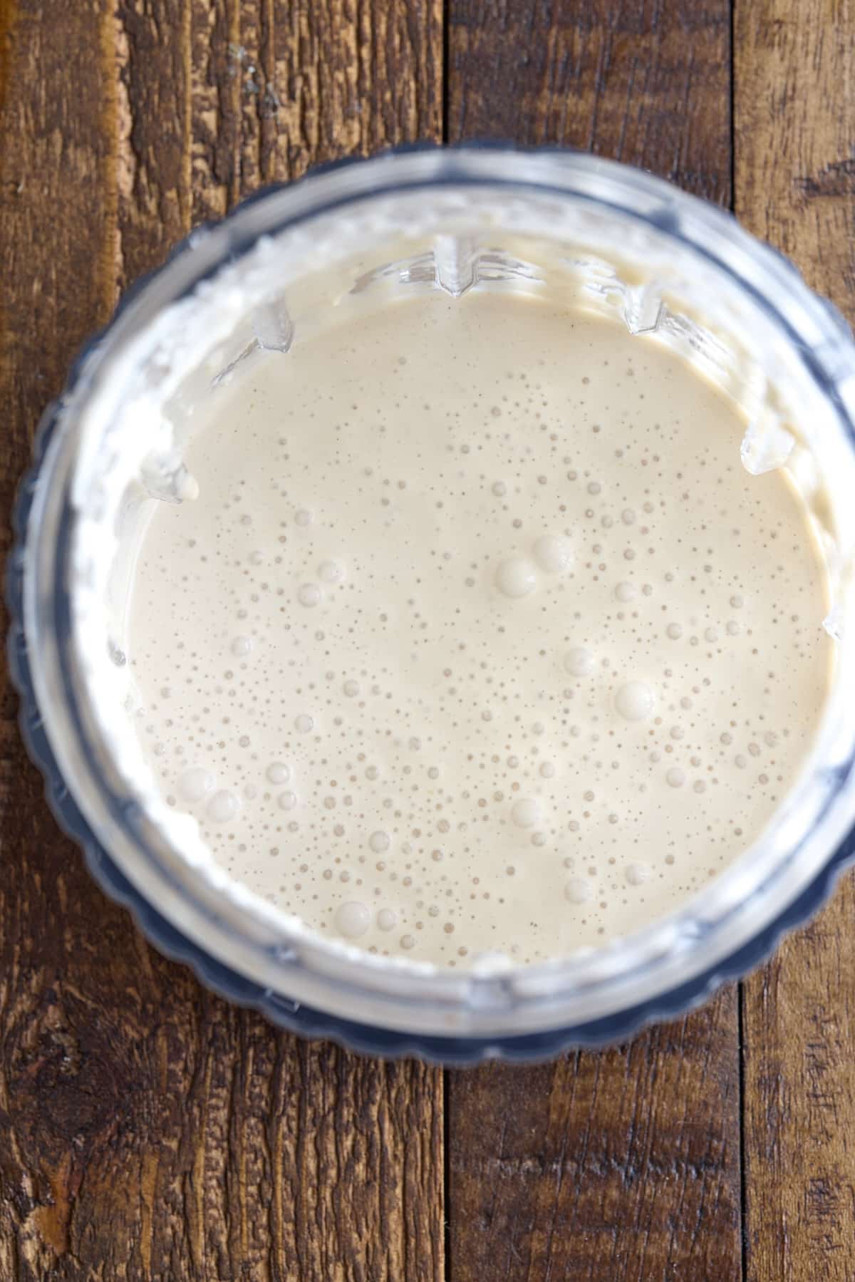 top down image of a jar of blue cheese dressing set on a wooden board