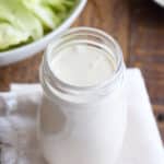 glass jar filled with blue cheese dressing set on a white linen napkin