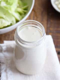 glass jar filled with blue cheese dressing set on a white linen napkin