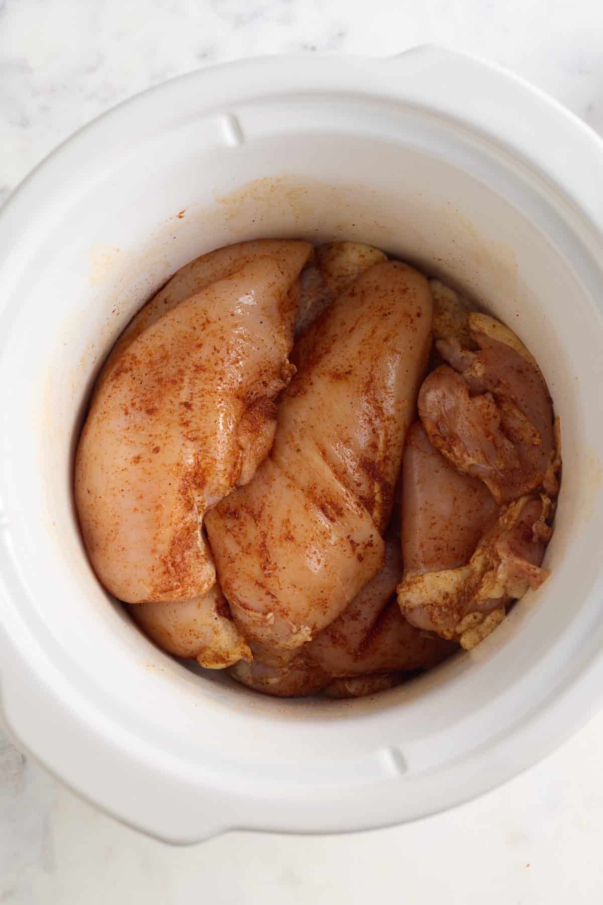 chicken breasts and thigh in the slow cooker insert.