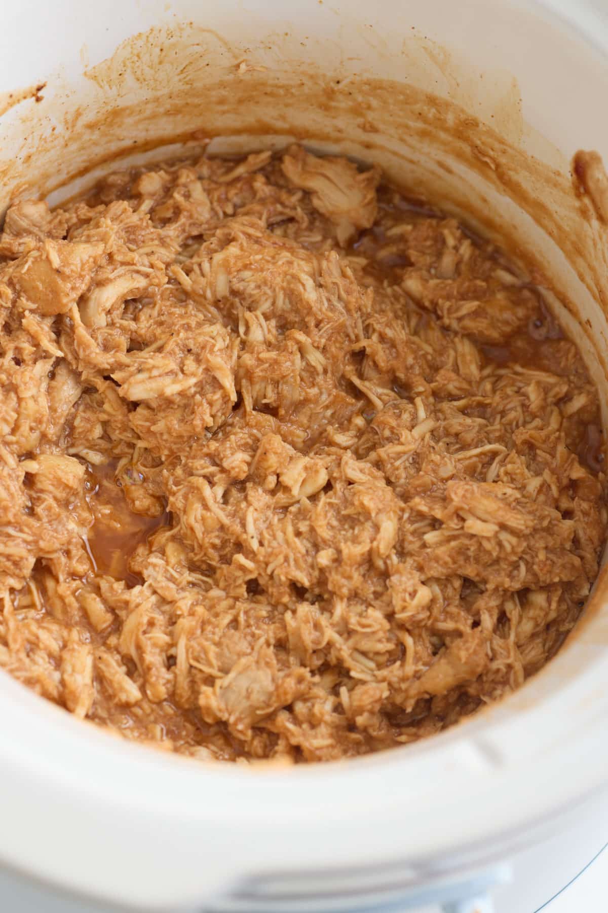 Shredded bbq chicken in the slow cooker insert.